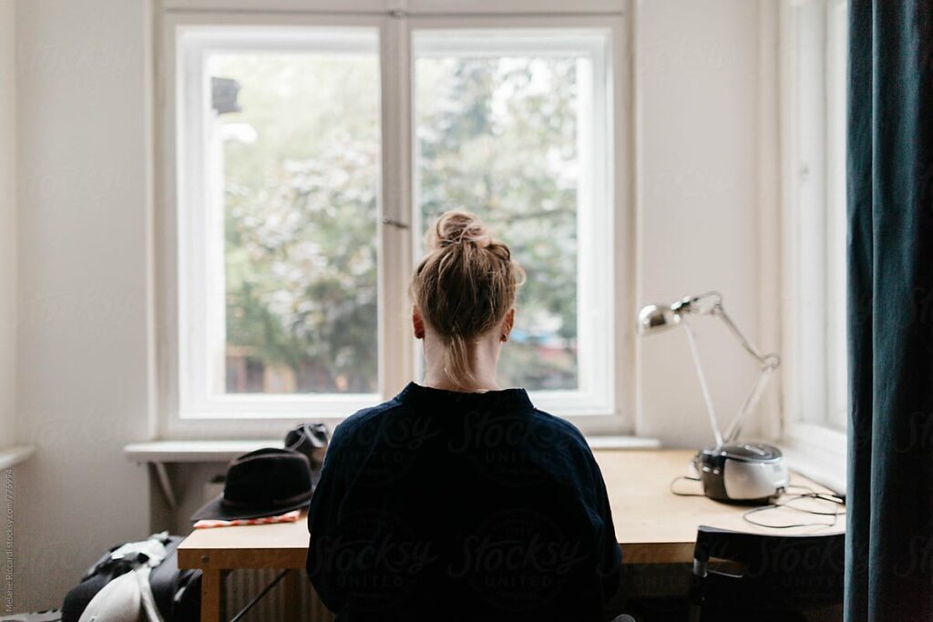 woman sitting at desk in front of window