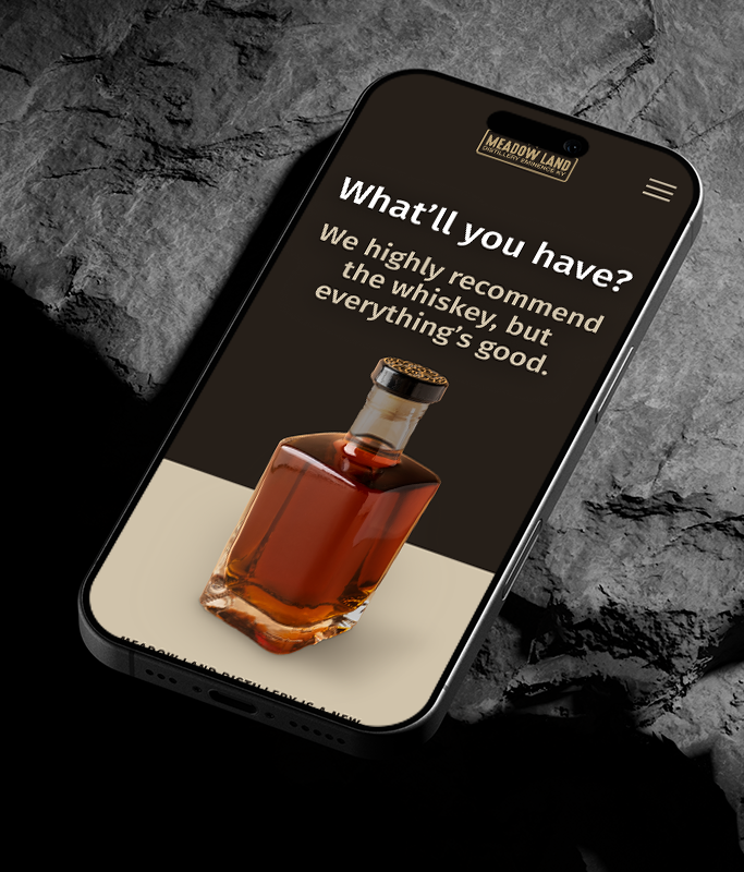 A smartphone displays a website with a whiskey bottle, Meadowland logo, and text recommending whiskey while highlighting the passion and purpose behind Meadow Lands brand distilling—reminding you that everything is good.