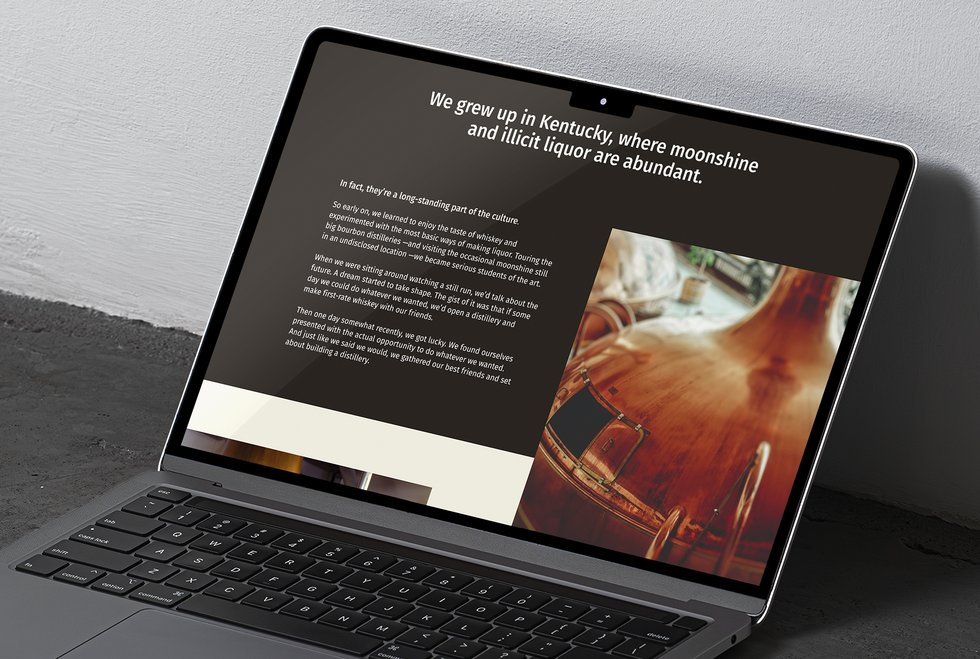 A laptop displays a website page featuring a heading about Kentucky, the Meadow Lands brand’s passion for distilling, a photo of a copper still, and a block of descriptive text on a dark background.