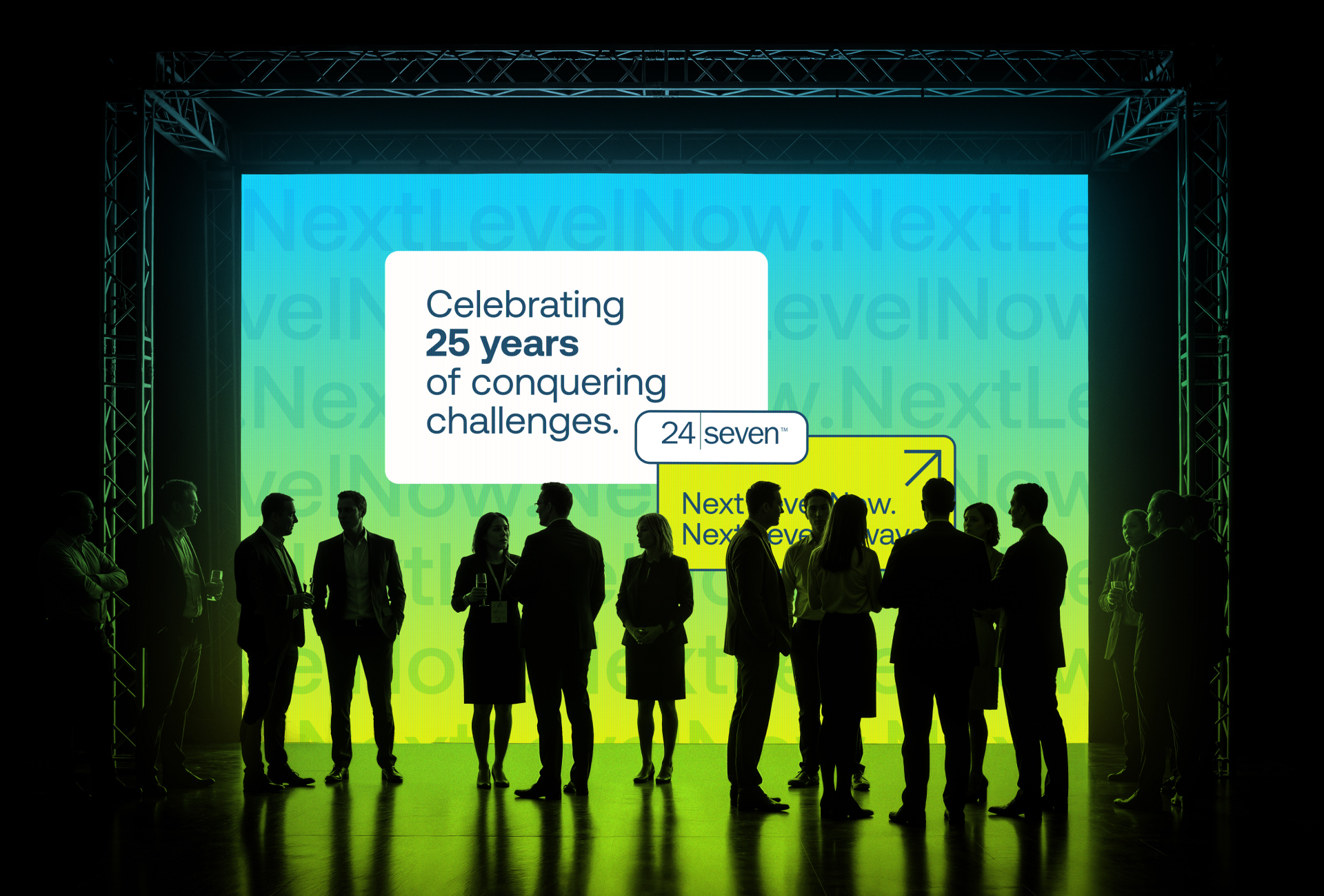 Silhouettes of people networking in front of a screen displaying "Celebrating 25 years of conquering challenges" and "24 Seven: Your partner in next-level success. NextLevelNow.