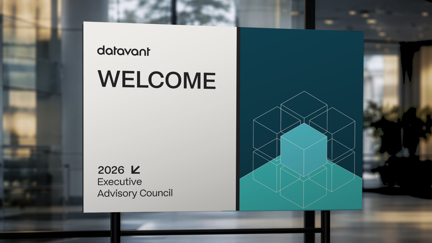 A welcome sign for Datavant’s 2026 Executive Advisory Council, featuring geometric cube designs, sets the tone for a unified executive experience in a modern office setting.