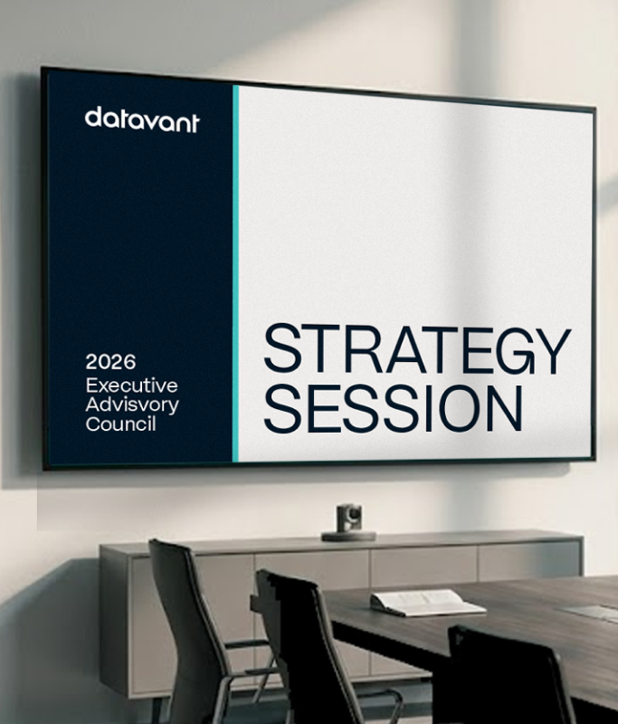 A wall-mounted screen in a conference room displays "datavant 2026 Executive Advisory Council STRATEGY SESSION," reflecting a premium executive experience. A table, chairs, and papers are visible in the room.