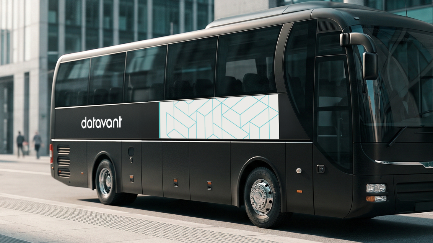 A black Datavant bus with a geometric pattern offers a premium executive experience as it sits parked on a city street near modern glass buildings.