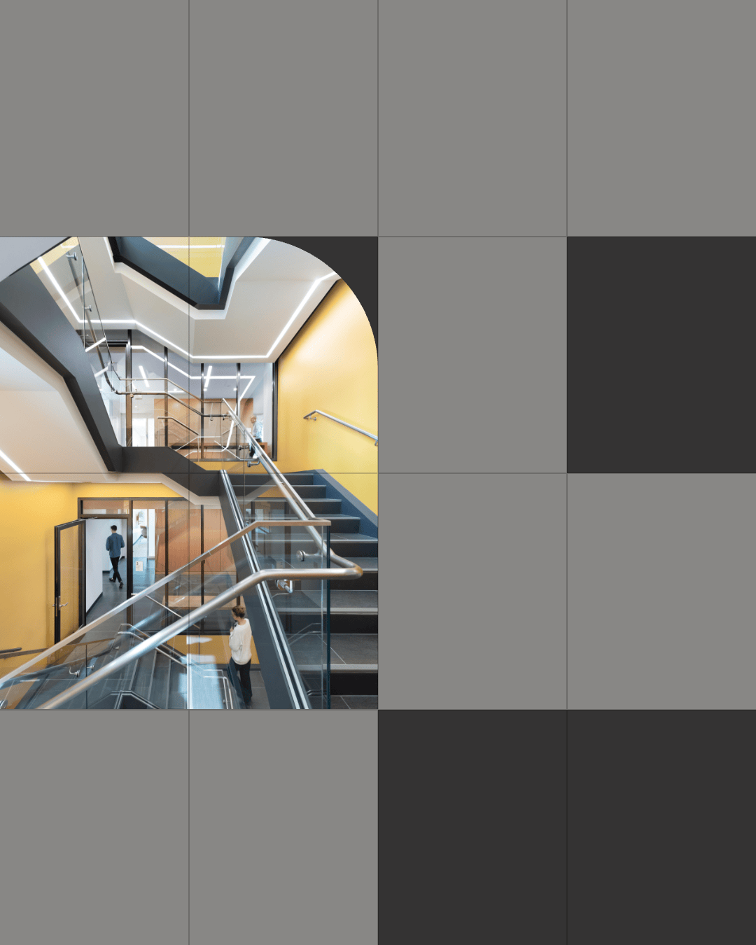 A modern stairwell by Nulite with glass railings and yellow walls, visible through a cut-out in a gray tiled wall, embodies premium brand identity as two people walk inside.