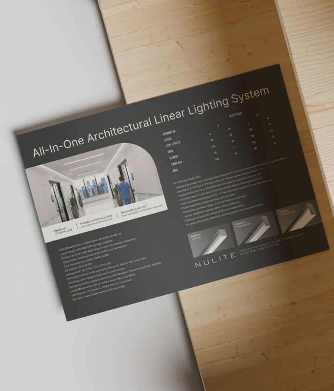 A brochure for Nulite’s all-in-one architectural linear lighting system sits on a wooden surface, displaying product photos, specifications, and company branding—perfect for driving brand growth and highlighting their core brand values.