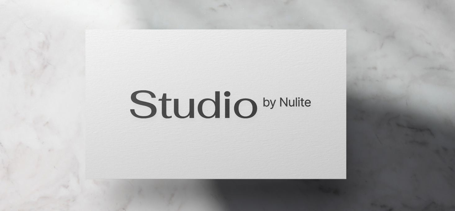 A white card with "Studio by Nulite" printed in black text, placed on a marble surface, reflects a premium brand identity and showcases Nulite’s path to growth.