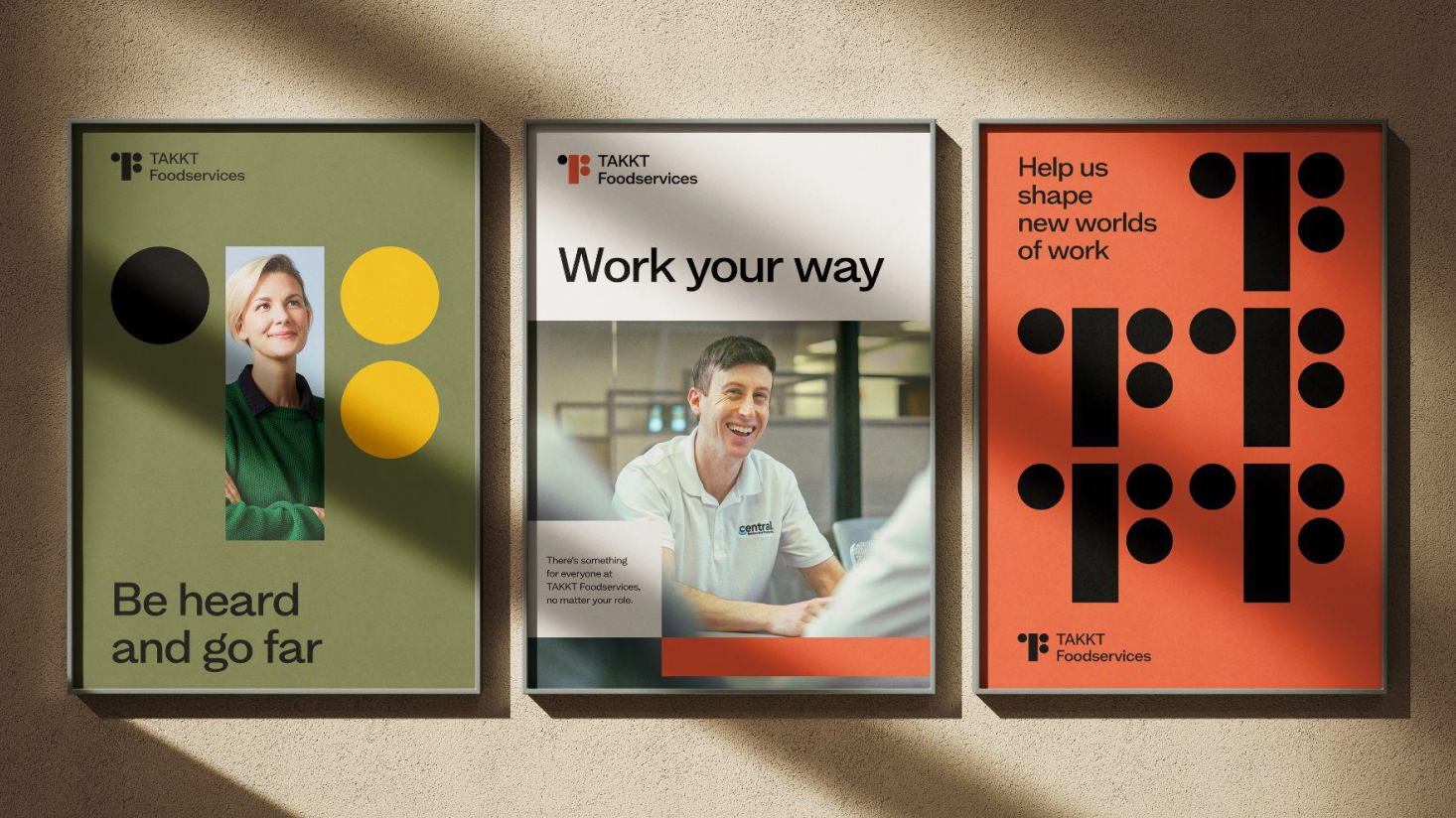 Three framed posters for TAKKT Foodservices brands are displayed on a wall, featuring bold graphics, photos of people, and text promoting workplace values.