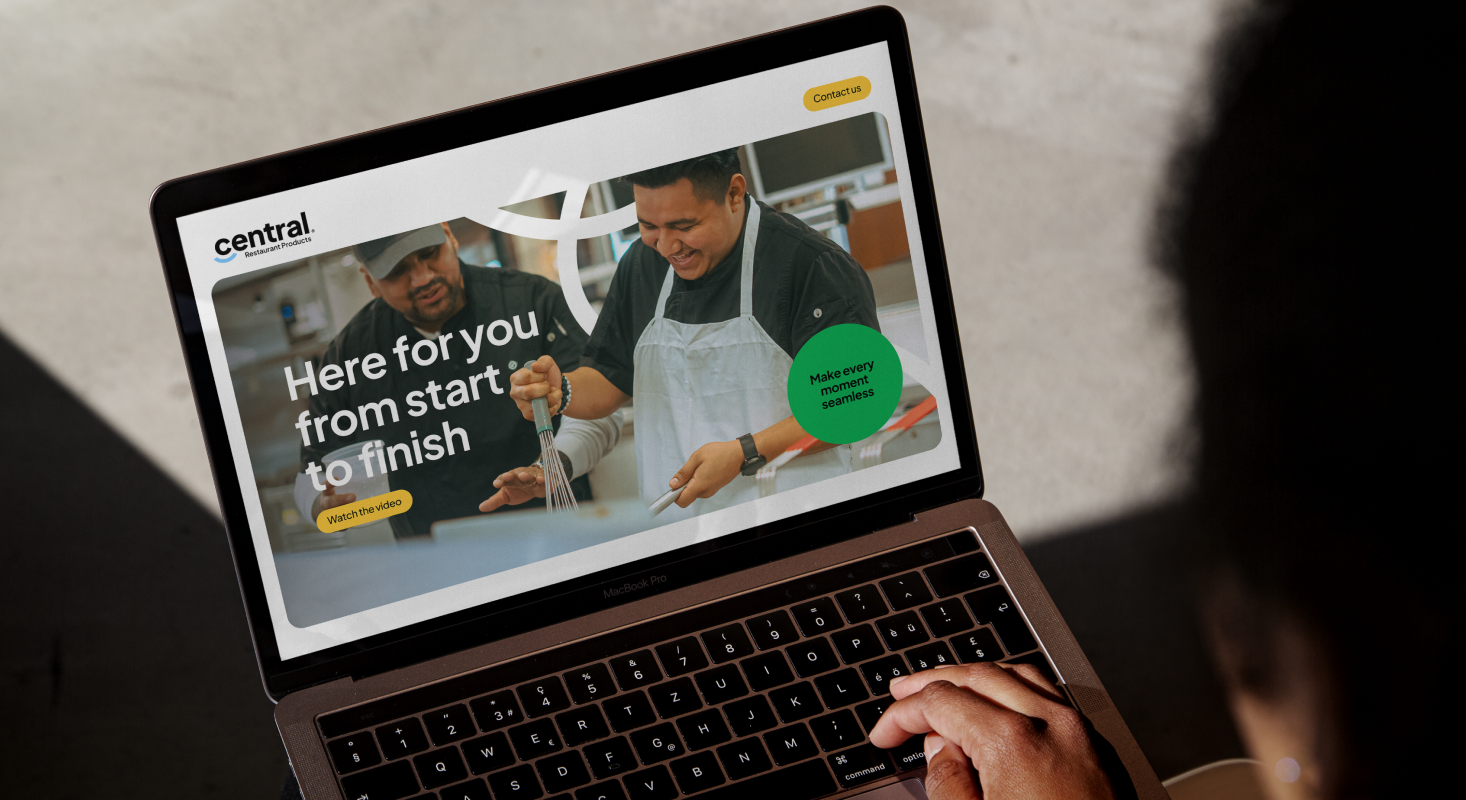 A person uses a laptop displaying a TAKKT Foodservices website with two people cooking and text that reads, "Here for you, from start to finish," plus a green button labeled "Make every experience personal." Perfect for brands mix inspiration.