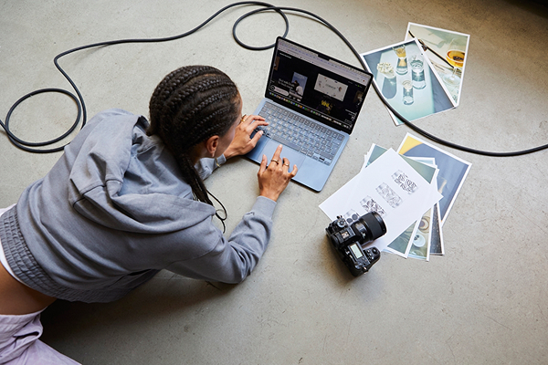 Person laying on ground working on AI video on computer